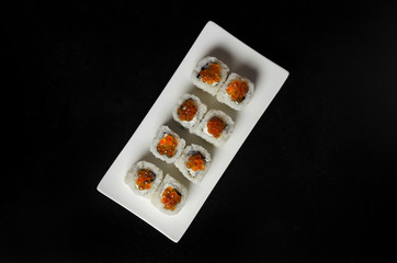 Obraz na płótnie Canvas Sushi with trout caviar on a plate slate with chopsticks