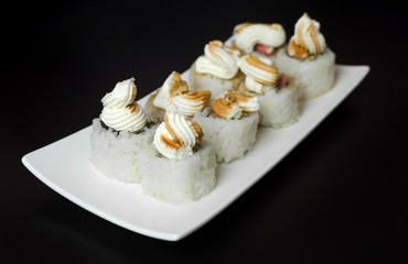 Sushi rolls with young cheese and trout on a black background