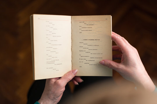 Old Woman Reading A Book With Russian Poetry