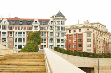 Fototapeta premium Famous dog of bilbao with buildings in the background
