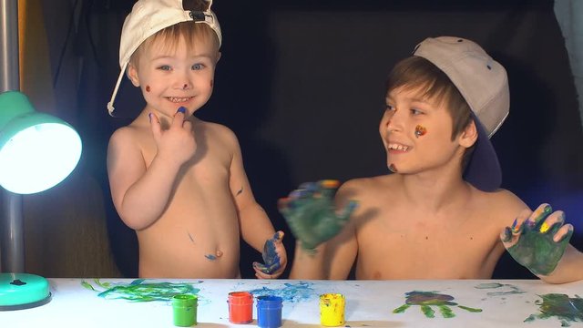 Two brothers draw color paints on the face. Family concept