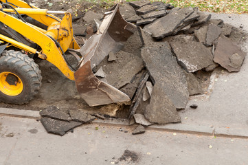 excavator removes the old asphalt