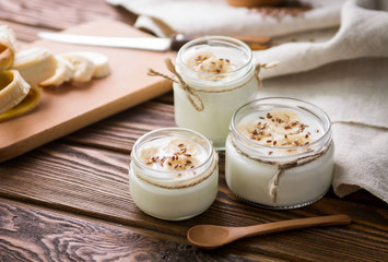 Yogurt in glass jars on wooden background