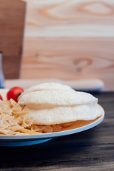 baked bread, pasta and tomatoes on a plate, wooden background