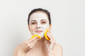 happy woman with a white mask on her face, yellow sponge