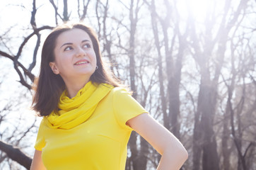 Fashion smiling lady girl in yellow dress in the park in the summer