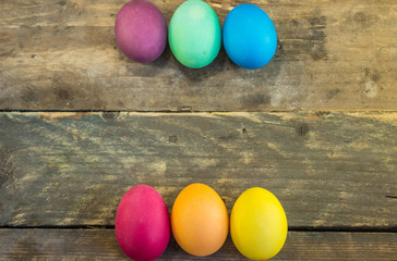 Row of colorful eggs on wooden desks