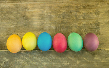Row of colorful easter eggs on wooden planks