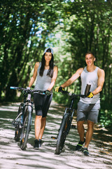 Fototapeta na wymiar Young Couple Riding Bike In Park