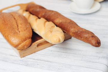 fresh bread on a tray and a light wooden table