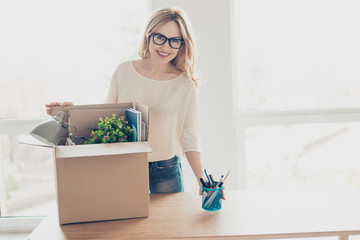 Concept of promotion at work. Portrait of attractive woman in spectacles unpacking her belongings...