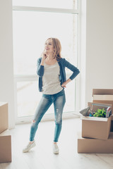 Happy smiling woman moving new house of her dream and thinking about where to put the furtinure