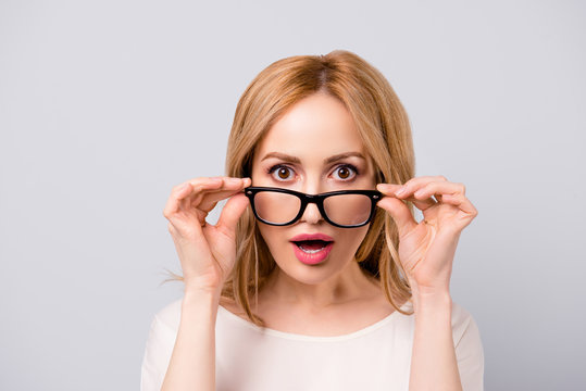 Attractive surprised business woman turning off her spectacles