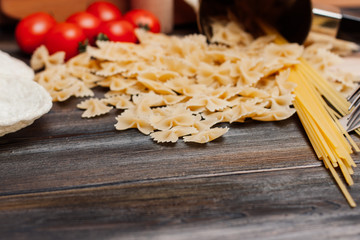 macaroni and red tomatoes, spaghetti on a wooden background