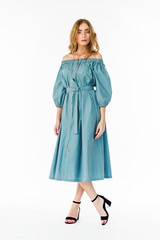 Fototapeta premium Young elegant female in light summer dress, over white background