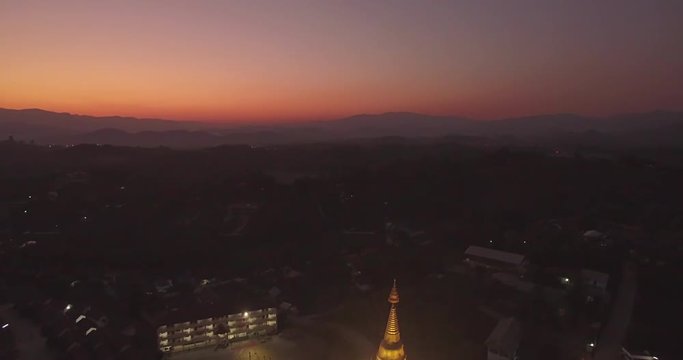 Illuminated Pagoda at Buddhist Temple in Chiang Rai, Thailand, Aerial Shot
