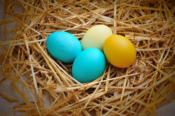 Colorful Easter egg decorations on natural straw
