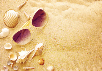 Seashells and sunglasses on sand, top view, toning. Sea summer vacation background with space for the text
