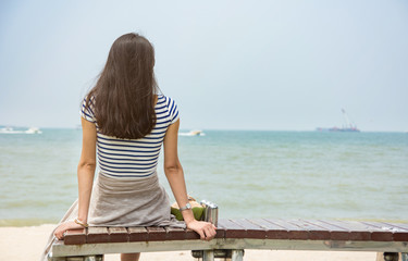 Girl looking at horizon sitting on a bench