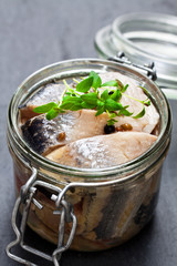 Pickled  herring on a black stone background