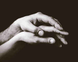A gentle touch of two hands. Concept of LGBT love, caring, tolerance, etc. Black and white, toned...
