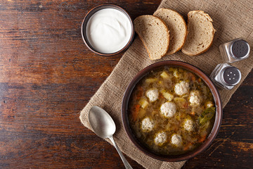 Soup with meatballs on a wooden table