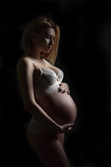 Pregnant woman silhouette over black background