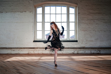 Obraz premium Piękna tancerka klapy z prześwitującą sukienką, nakryciem głowy i długimi rudymi włosami; taniec