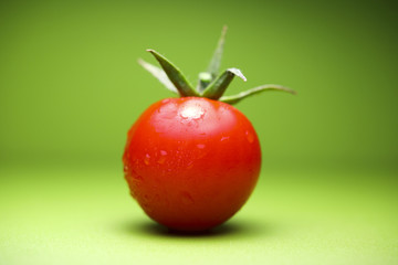 Cherry tomatoes on green background