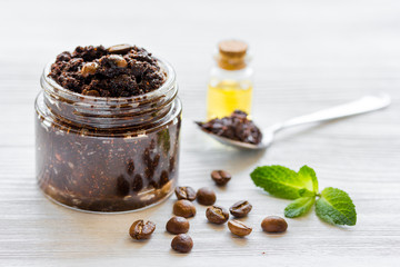 Body scrub of ground coffee with oil on white table background