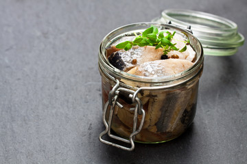 Pickled  herring on a black stone background