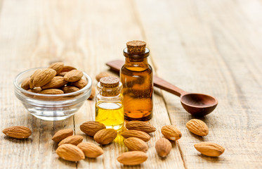 spa with almond oil in organic cosmetic set on wooden background