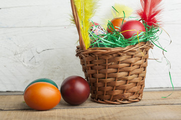 Easter eggs in basket and natural wooden country table copyspace