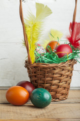 Easter eggs in basket and natural wooden country table copyspace