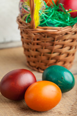 Easter eggs in basket and natural wooden country table copyspace