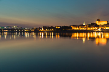 Naklejka premium City of Torun in Poland, old town skyline by night from Vistula river
