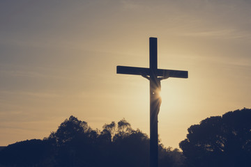 Jesus Christ on the cross silhouette at sunset - crucifixion on the Calvary Hill. Good Friday...