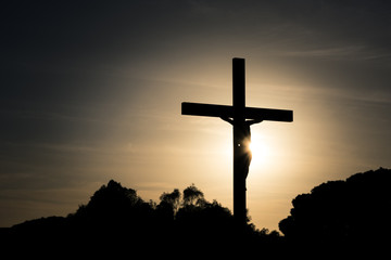 Jesus Christ on the cross silhouette at sunset - crucifixion on the Calvary Hill. Good Friday...