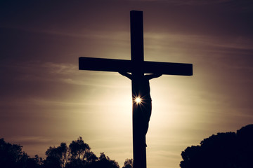 Jesus Christ on the cross silhouette at sunset - crucifixion on the Calvary Hill. Good Friday...