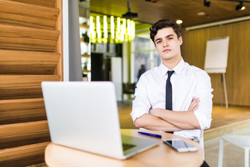 Portrait of a smiling manger with hands crossed at chest in front of office place