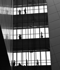Fototapeta premium silhouettes of business people rushing at morden office building.