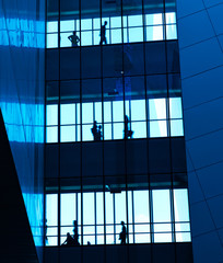 silhouettes of business people rushing at morden office building.