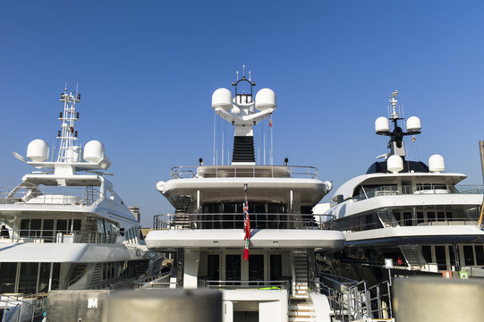 Modern yachts with massiv radar navigation systems at the stern at a jetty against blue skies