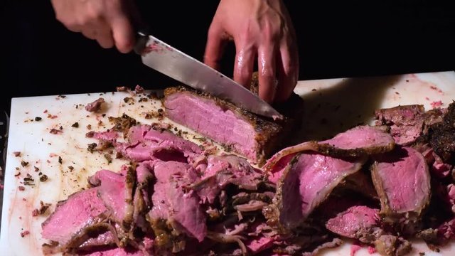 Chef cuts a juicy roast beef.