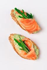 Two bruschettes with arugula in fillet of tuna and green sauce