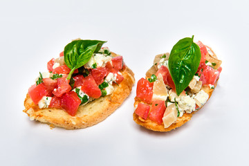 Two bruschettes with cheese Feta, basil and meat pieces