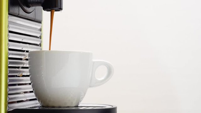 pour coffee with coffee maker in a white cup on a clear backgroud at the breakfast