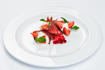 Strawberry and mint in white cream covered with sliced jamon.