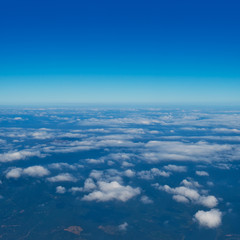 Fototapeta na wymiar Blue sky with white clouds, view from a flying airplane.
