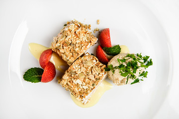 Meat covered in crumpet of pumpkin seeds served on plate.